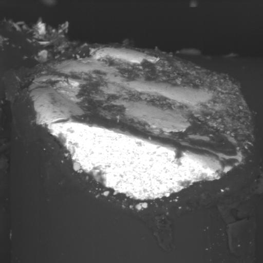 Higher magnification SEM image of broken magnet wire end with wedge-shaped feature